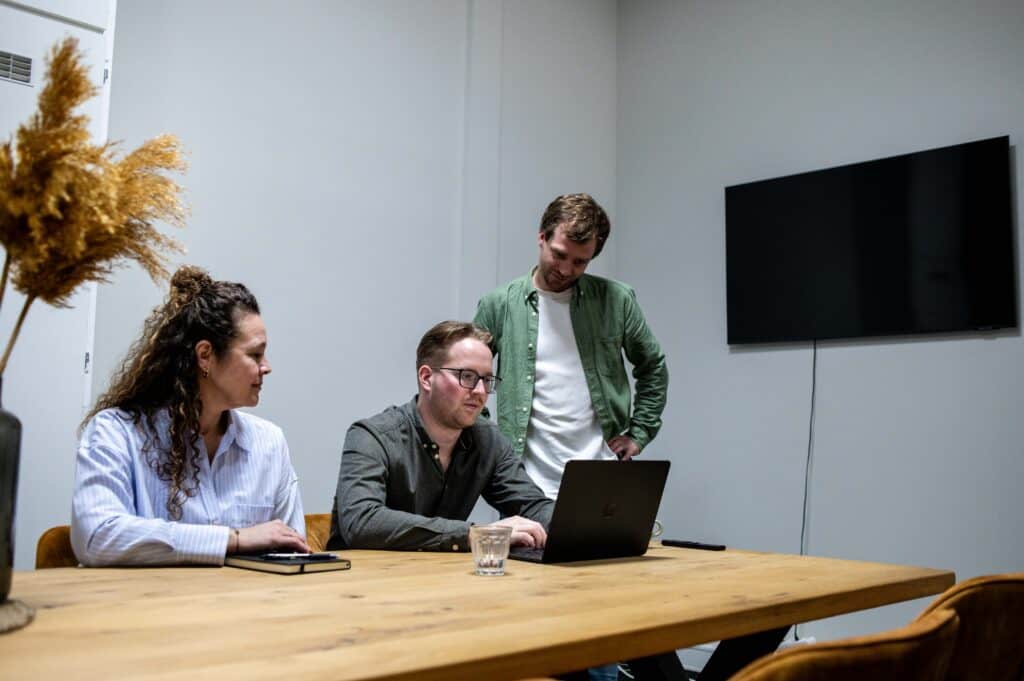 Team bespreekt technische optimalisaties voor een website aan een vergadertafel.